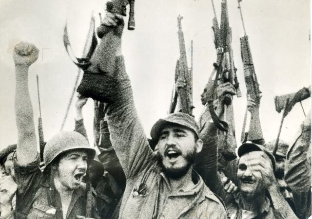 Con los fusiles en alto cantando el Himno Nacional en la cima del Turquino
